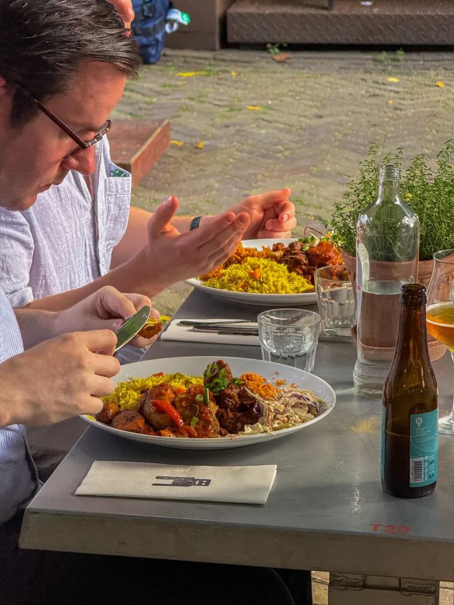 Bord met jollof rijst, stoofvlees en salade van de catering van Bukka 9